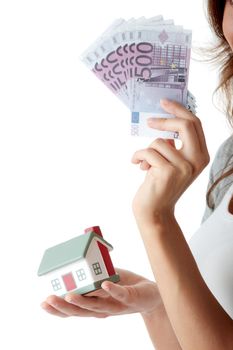 Beautiful young woman holding euros bills and house model over white