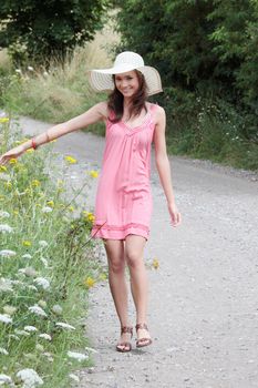 a beautiful girl in big summer hat in the country
