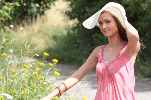 a beautiful girl in big summer hat in the country
