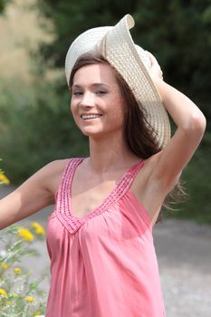 a beautiful girl in big summer hat in the country