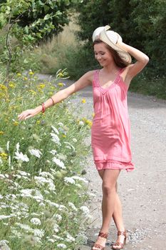 a beautiful girl in big summer hat in the country