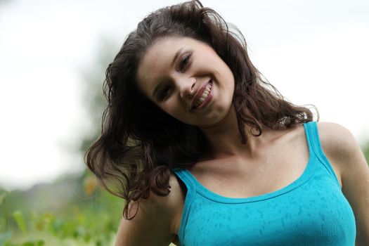 Beautiful young woman relaxing in the grass (rain in summer)