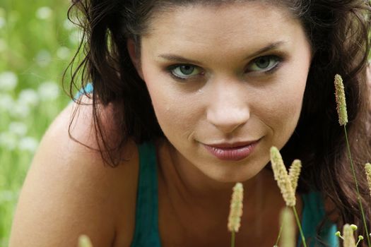 Beautiful young woman relaxing in the grass (rain in summer)
