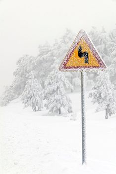 Traffic road sign in frost and snow