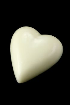 White chocolate love heart isolated against a black background