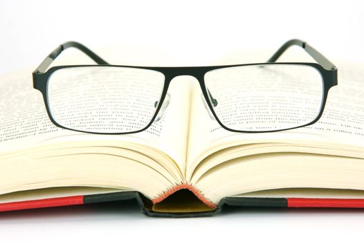 Reading glasses and books isolated against a white background