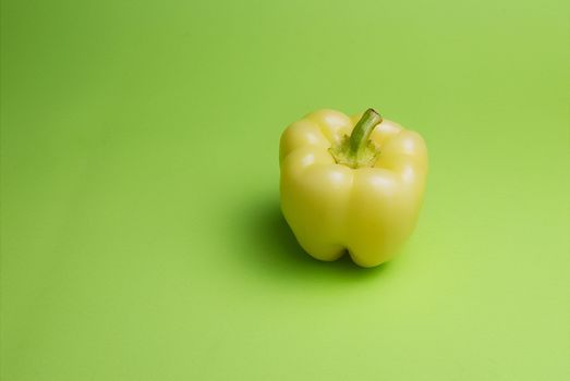 Yellow pepper on green background