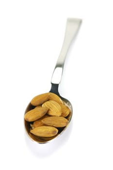 Almonds in a spoon isolated against a white background