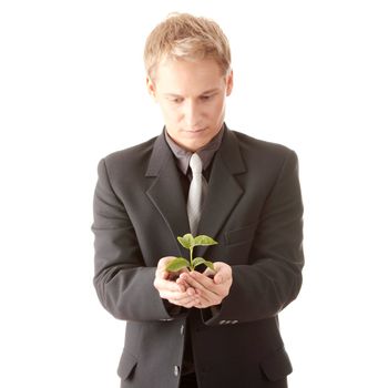 Businessman in dark suit holding smal plant in his hands - growth concept