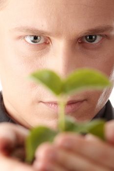 Businessman in dark suit holding smal plant in his hands - growth concept