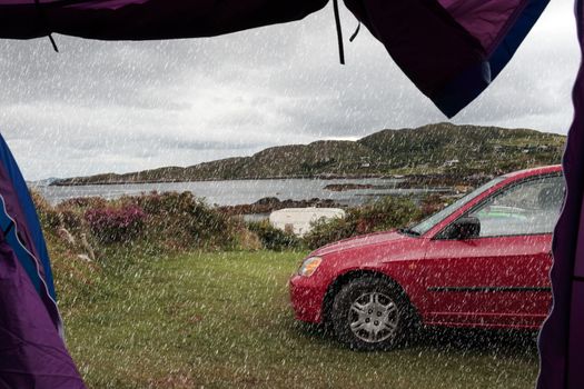 car and tent at campsite on the edge of the coast of kerry in ireland in the rain