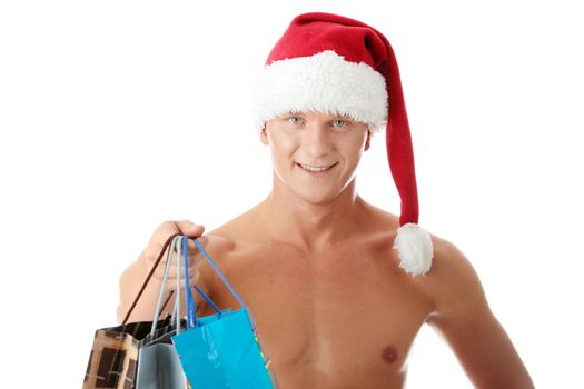 Sexy muscular shirtless man in Santa Claus hat with shopping bags isolated on white