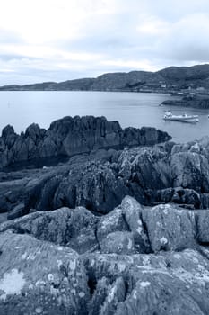 a lone boat amongst the rocks on the coast of kerry in ireland