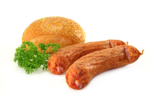 two sausages with roll and parsley on a white background