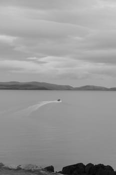 a lone boat amongst the rocks on the coast of kerry in ireland