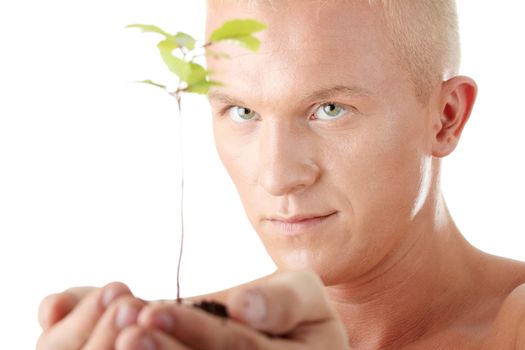 Muscular man holding small plant and soil in his hands. Isolated on white in studio.