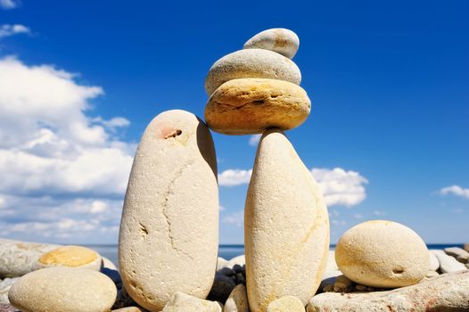 Pebble in balance between the two boulders against the cloudy sky