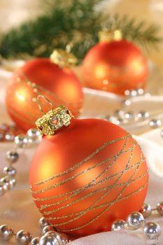Golden Christmas tree balls and pearl necklace on silk fabric