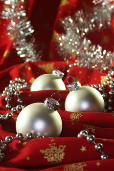 silver christmas ball and pine branches on Christmas fabric