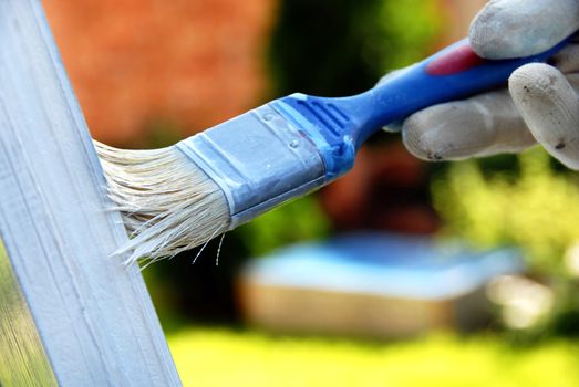 painting wooden door in white color by blue brush