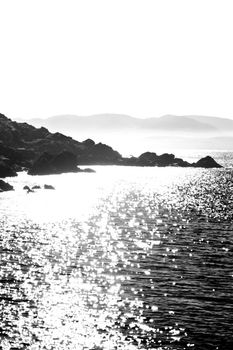 scenic view in kerry ireland of rocks and sea with mountains against a beautiful bright sky