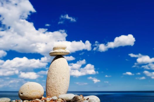 Pebbles on top of a long cobblestone against a background the cloudy sky