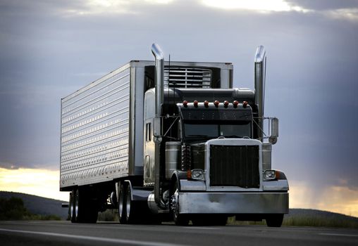 big truck driving on a highway with cloudy sky in background