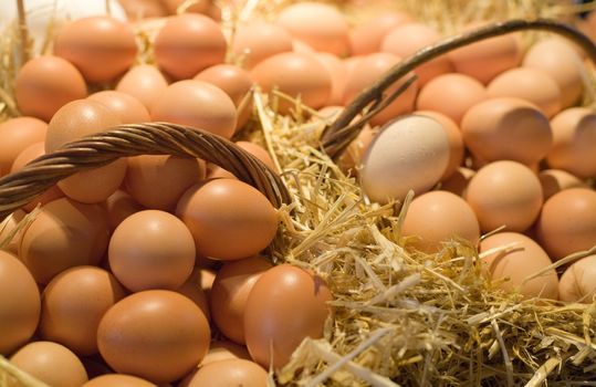 Tiled eggs in straw baskets on market stall.