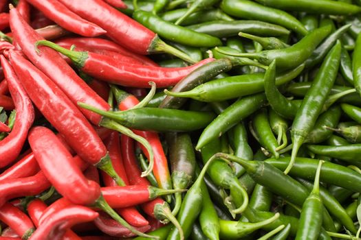 Red and green chilli peppers on market stall.