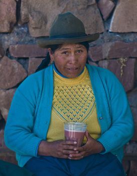 Cusco , Peru - May 27 : Peruvian woman drink "Chicha"  , "Chicha" is drink common throughout Latin America originated with the Incas , the photo was taken in Cusco Peru on May 27 2011