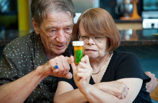 Senior couple at home with prescription bottle