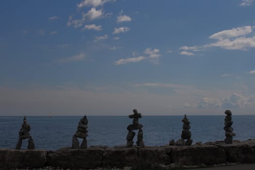 collection of inukshuk statue or monument by the lake