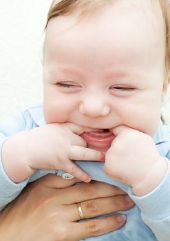 Adorable laughing baby boy in mothers' hands
