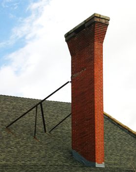 Old red brick chimney with clouds in the background