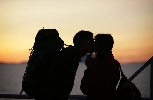 young couple kissing at sunset