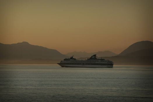 cruse ship at sunset with mountains in background