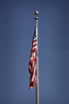 american flag hanging down with blue sky 