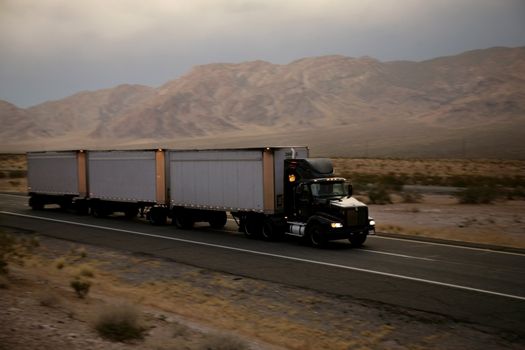 truck driving on a freeway at sunset