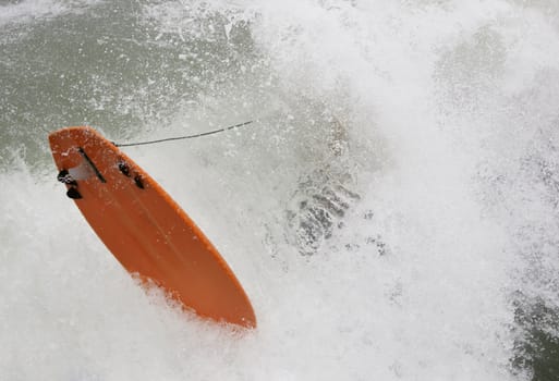 surfer with orange surfboard jumping into a wave