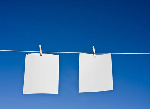 paper hanging from a clothes line with a blue background