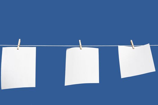 paper hanging from a clothes line with a blue background