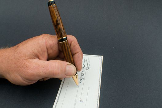 male hand writing check to IRS for Too many dollars