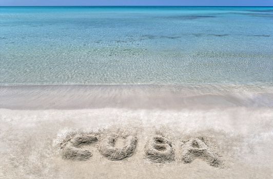 Cuba word written on a sandy beach in the Caribbean.