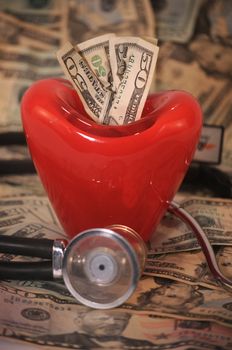 close up of stethescope and  red heart on a background on twenty and fifty dollar bills