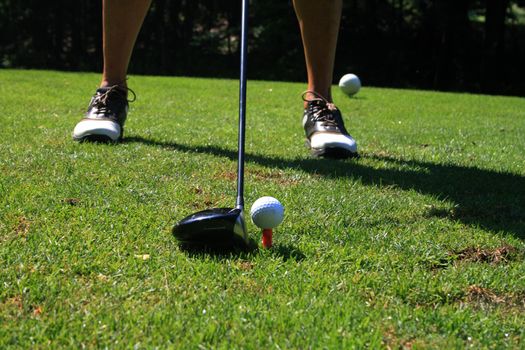 Golfer setting up to make a drive on tee