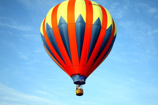 Hot air balloon on light blue background with red blue and yellow highlights.