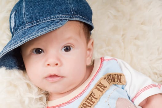 Shot of trendy newborn boy in denim cap