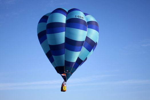 Striped blue hot air balloon on blue sky background