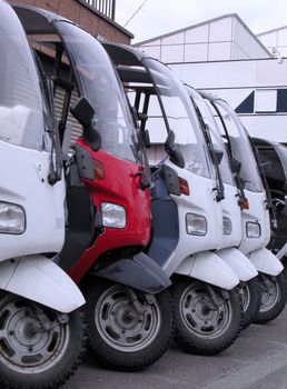 Scooters in a row in a front of motor-service shop.          