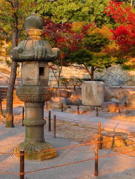 Amazing colors and lighting in an autumn Japanese garden with stone lantern          